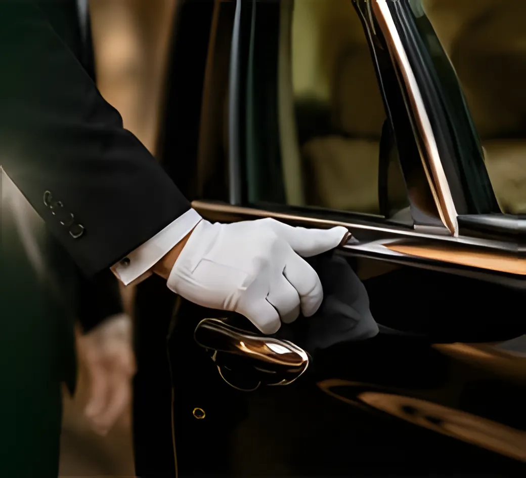Main gantée de blanc d’un chauffeur ouvrant la portière d’une berline